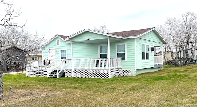 rear view of property with roof with shingles and a yard