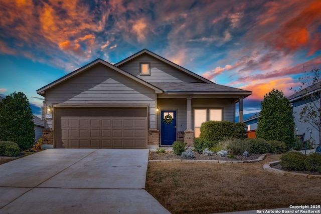 view of front of home with concrete driveway, brick siding, and an attached garage