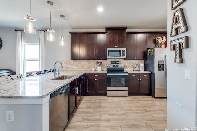 kitchen with stainless steel appliances, a sink, dark brown cabinetry, and decorative backsplash