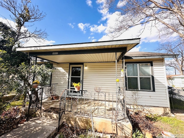 view of front of home with fence and a porch