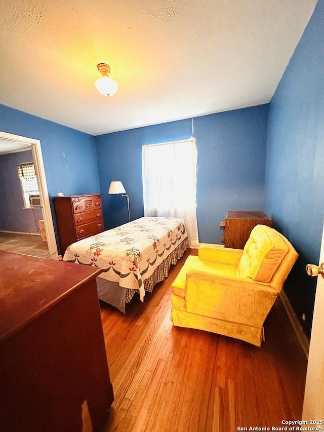 bedroom featuring a textured ceiling and wood finished floors