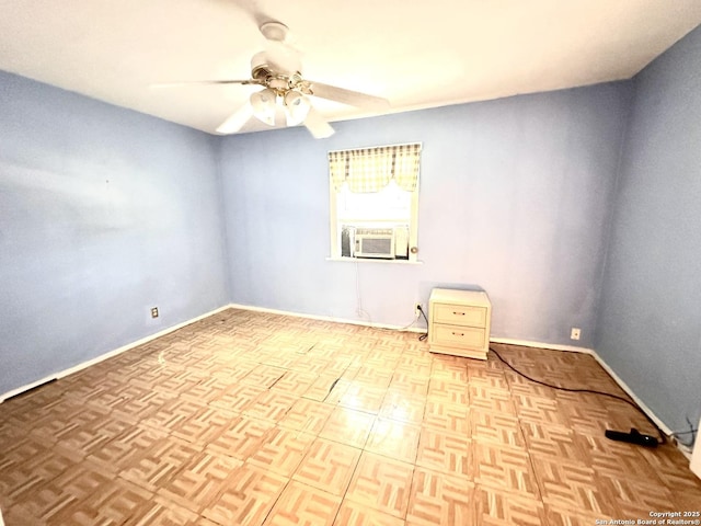 empty room featuring cooling unit, ceiling fan, and baseboards