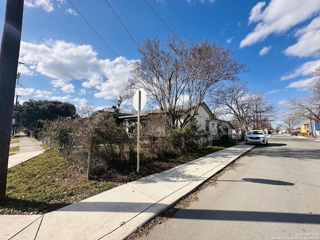 view of road featuring curbs, traffic signs, and sidewalks