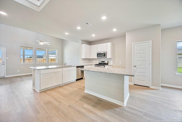 kitchen with appliances with stainless steel finishes, visible vents, light wood-style flooring, and white cabinetry