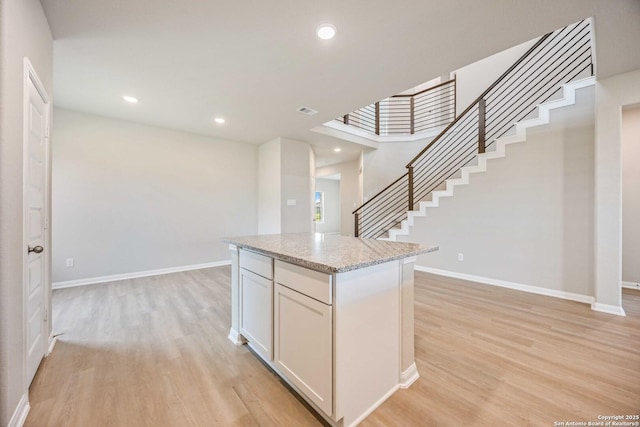 kitchen with baseboards, recessed lighting, a center island, and light wood-style floors