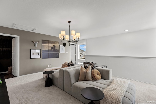 interior space featuring attic access, carpet, baseboards, and an inviting chandelier