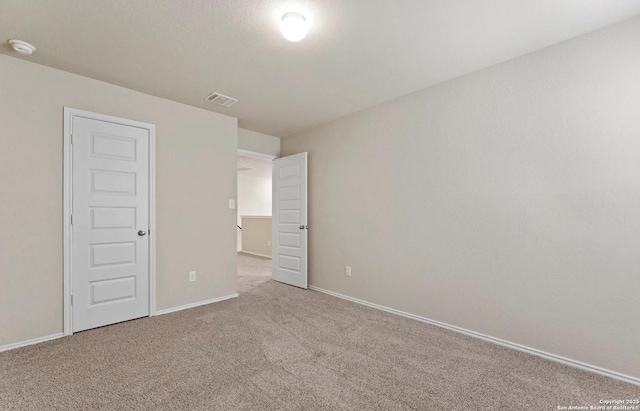 unfurnished bedroom with carpet, visible vents, and baseboards