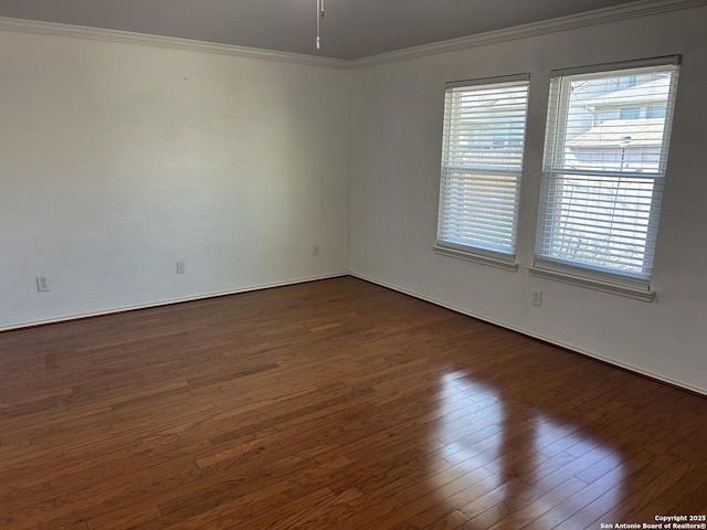 unfurnished room featuring dark wood-type flooring, a wealth of natural light, and ornamental molding