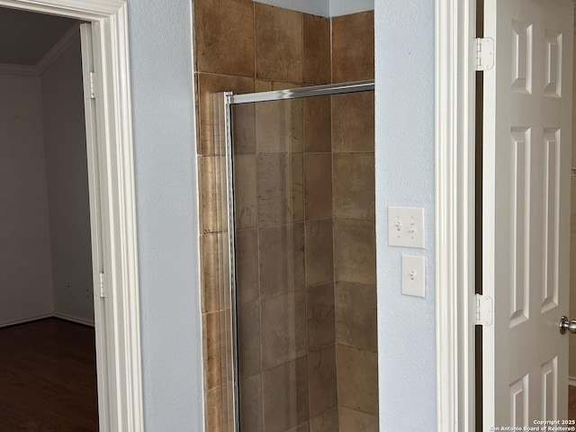 full bath with a shower stall and wood finished floors