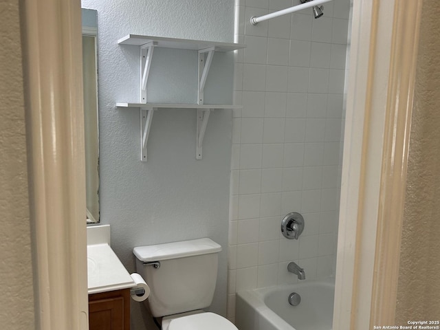 bathroom featuring toilet, a textured wall, shower / tub combination, and vanity