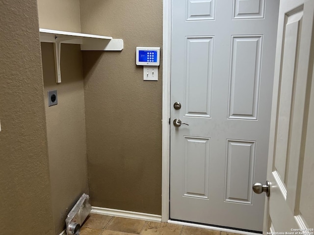 washroom featuring laundry area, tile patterned flooring, hookup for an electric dryer, and a textured wall