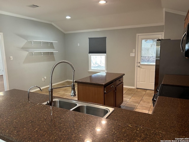 kitchen with plenty of natural light, visible vents, lofted ceiling, crown molding, and a sink