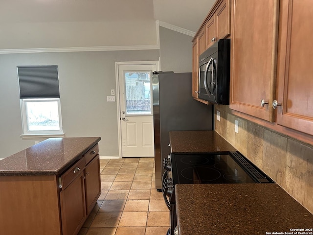 kitchen with vaulted ceiling, ornamental molding, decorative backsplash, dark stone counters, and black appliances