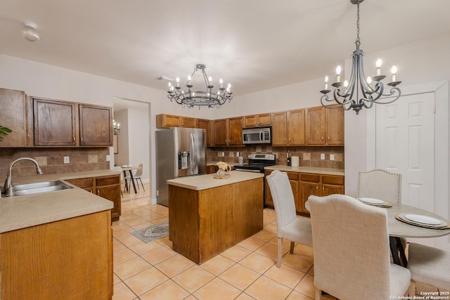 kitchen featuring light tile patterned floors, stainless steel appliances, light countertops, an inviting chandelier, and a sink