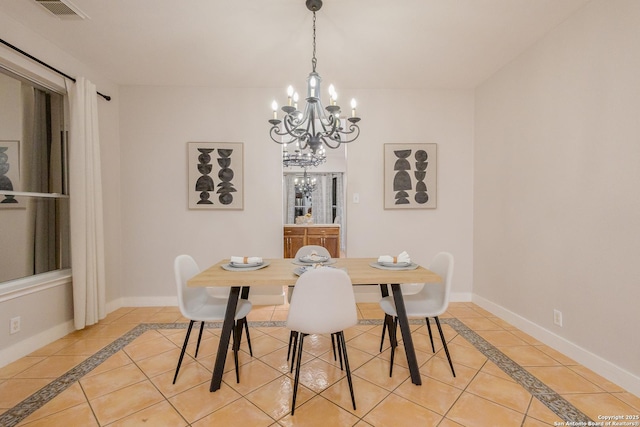 dining space featuring light tile patterned floors, a notable chandelier, visible vents, and baseboards