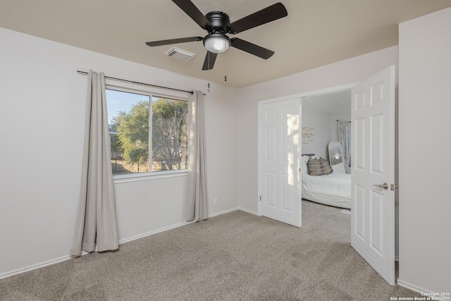 unfurnished bedroom with carpet flooring, ceiling fan, visible vents, and baseboards