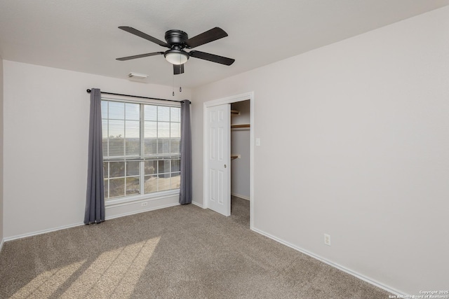 unfurnished bedroom with carpet flooring, a ceiling fan, visible vents, baseboards, and a closet