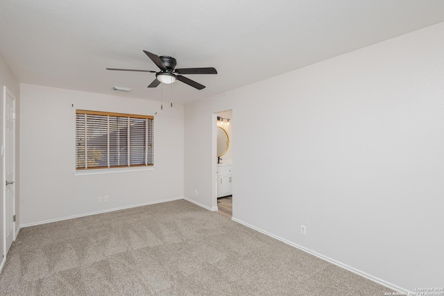 unfurnished room featuring a ceiling fan, light colored carpet, visible vents, and baseboards