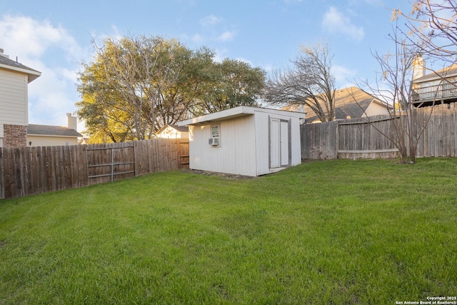 view of yard featuring an outbuilding, a fenced backyard, and a storage shed