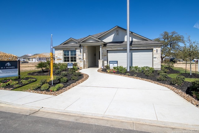 view of front of home with driveway, stone siding, and an attached garage