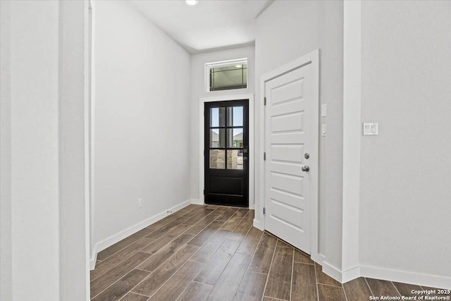 entryway with baseboards and wood finish floors