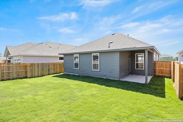 back of house with a patio area, a fenced backyard, a shingled roof, and a lawn