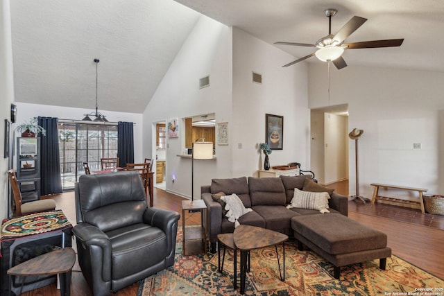 living room with lofted ceiling, ceiling fan, wood finished floors, and visible vents