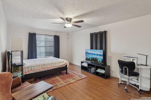 bedroom with ceiling fan, a textured ceiling, and wood finished floors