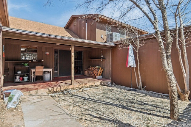 back of property featuring a patio and roof with shingles