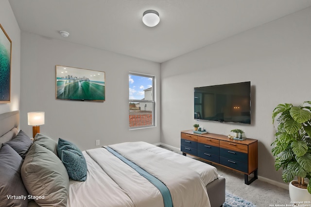 bedroom with light colored carpet and baseboards