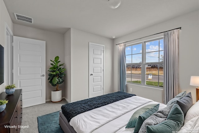 carpeted bedroom featuring visible vents and baseboards