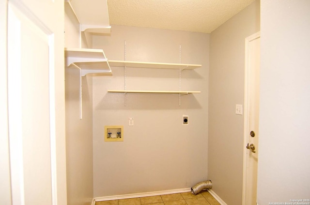 1102 E Hancock, Beeville, TX 78102 - laundry area with hookup for an electric dryer, washer hookup, light tile patterned floors, a textured ceiling, and baseboards