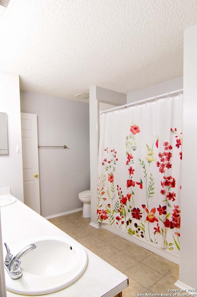 1102 E Hancock, Beeville, TX 78102 - full bathroom featuring double vanity, a textured ceiling, tile patterned flooring, and curtained shower