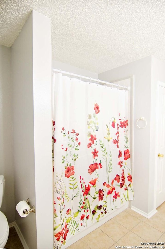 1102 E Hancock, Beeville, TX 78102 - full bathroom featuring a textured ceiling, toilet, tile patterned floors, and a shower with curtain