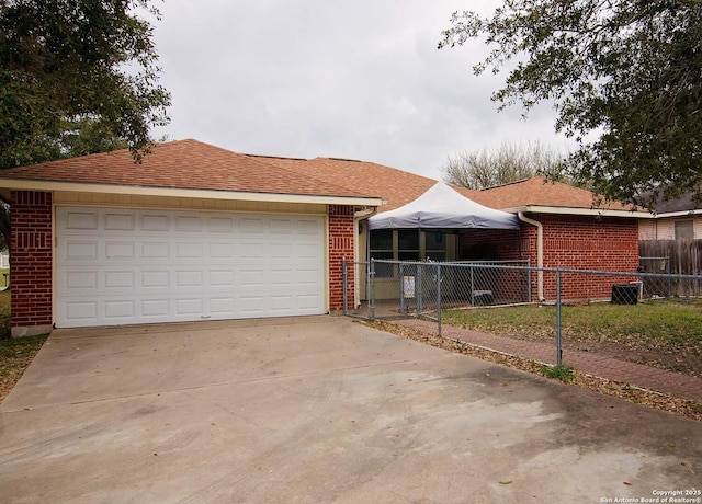 1102 E Hancock, Beeville, TX 78102 - ranch-style house featuring brick siding, a garage, concrete driveway, and roof with shingles