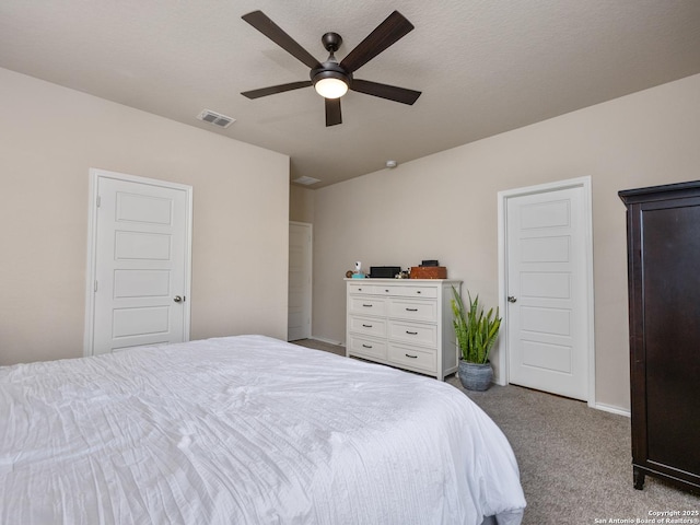 carpeted bedroom featuring ceiling fan, visible vents, and baseboards