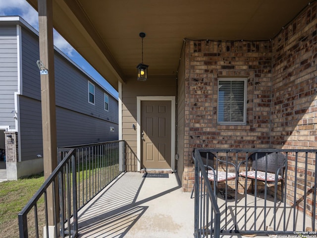 property entrance with a patio and brick siding