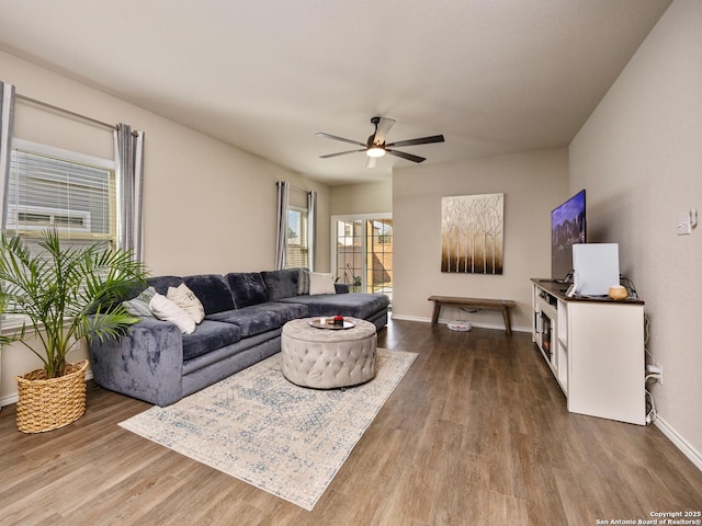 living room featuring ceiling fan, dark wood finished floors, and baseboards