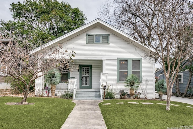 bungalow-style house with covered porch and a front lawn