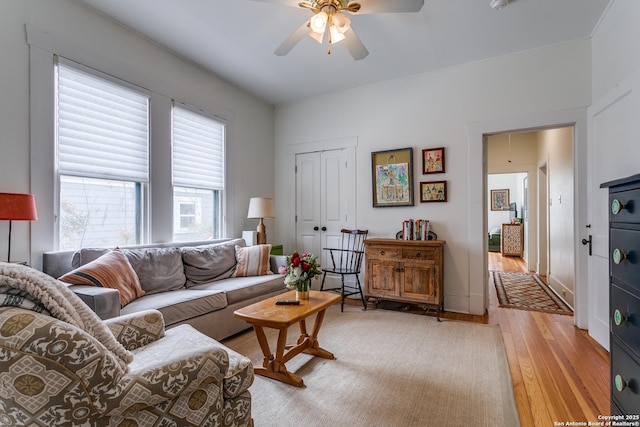 living area with light wood-style flooring and a ceiling fan