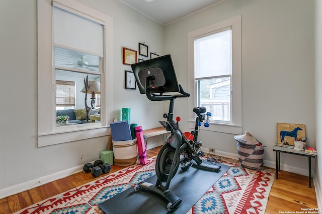 workout area featuring wood finished floors and baseboards