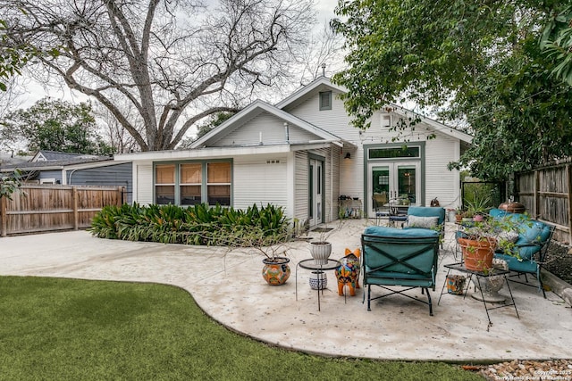 rear view of property featuring a yard, a patio area, and a fenced backyard