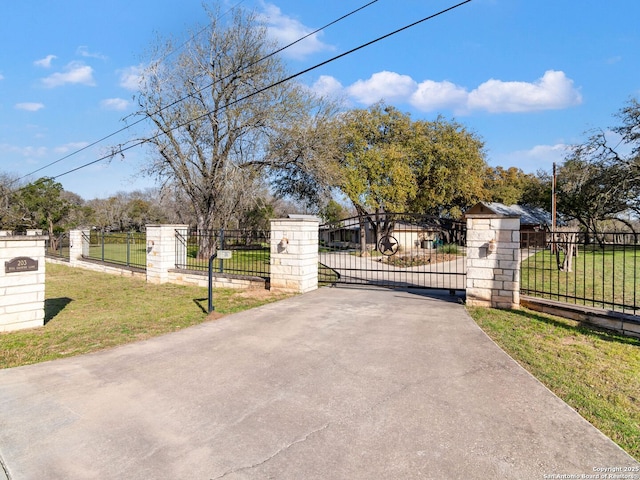 view of gate with a yard and fence