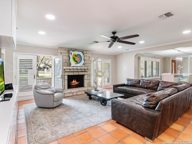 living room with visible vents, plenty of natural light, a fireplace, and crown molding