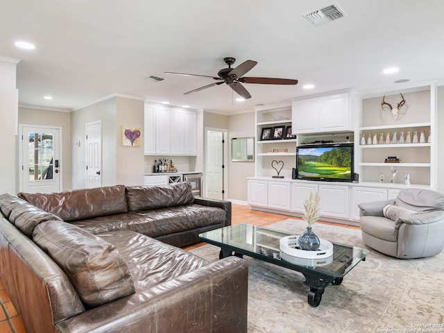 living area with recessed lighting, visible vents, indoor bar, and ornamental molding