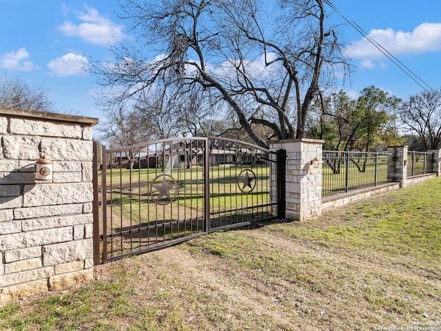 view of gate featuring a lawn and fence