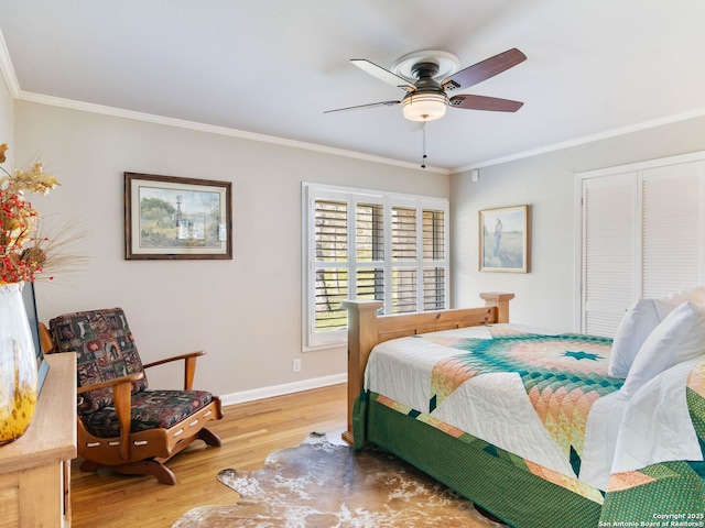 bedroom featuring a closet, wood finished floors, baseboards, and ornamental molding