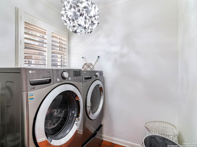 laundry room featuring ornamental molding, washer and clothes dryer, baseboards, a chandelier, and laundry area