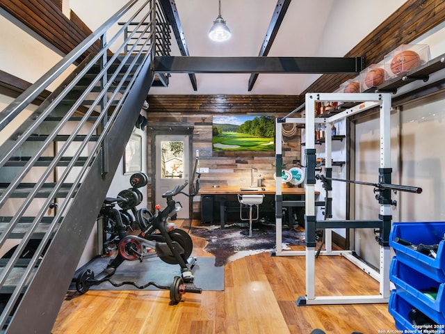 workout area featuring wood finished floors and wood walls