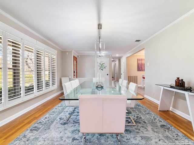 dining area with visible vents, ornamental molding, baseboards, and wood finished floors